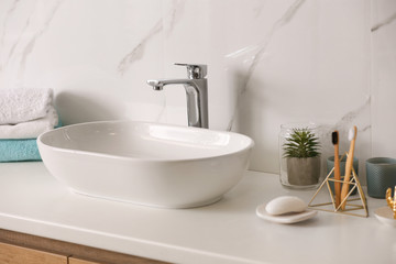 Naklejka na ściany i meble Stylish vessel sink on light countertop in modern bathroom