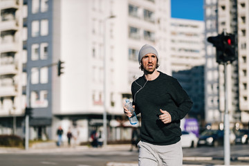 Young male runner jogging in the city.