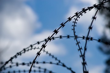 Barbed wire barrier war territory, roadblock quarantine on background.