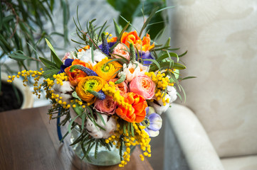 Bouquet of yellow ranunculus in glass vase near the window, horizontal photo. Bright bouquet of...