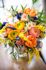 Bouquet of yellow ranunculus in glass vase near the window, horizontal photo. Bright bouquet of flowers