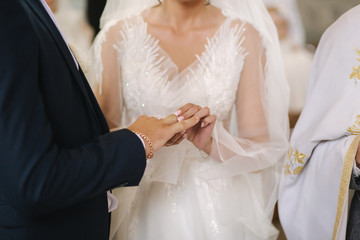 Close up hands of groom and bride in the church. wedding