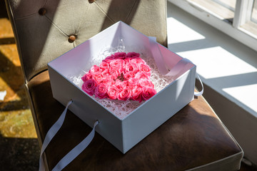 Pink roses bouquet in a shape of heart lying in white gift box. Valentine's day, Mother's day, wedding, dating, romance, love concept. Top view, tabletop. 