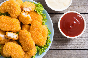 Chicken nuggets in plate on rustic background
