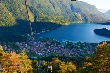 Aerial view over the beautiful Molveno town and Molveno lake, an alpine lake in Trentino, Italy