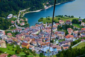 Aerial view over the beautiful Molveno town and Molveno lake, an alpine lake in Trentino, Italy