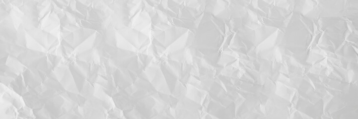 white and gray wide crumpled paper texture background. crush paper so that it becomes creased and wrinkled.