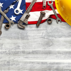 Labor day or American labor concept with construction and manufacturing tools on patriotic US, USA, American flag on white wooden background