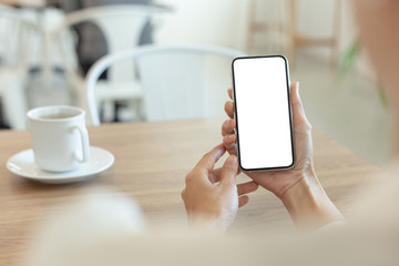Mockup image blank white screen cell phone.woman hand holding texting using mobile on desk at coffee shop.background empty space for advertise text.people contact marketing business,technology