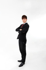 Obraz na płótnie Canvas Young smart handsome Asian man business office wearing suit tie on white background stand side hands folded look at camera