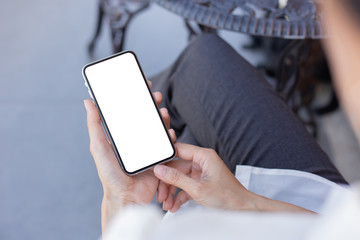 Mockup image blank white screen cell phone.woman hand holding texting using mobile on desk at coffee shop.background empty space for advertise text.people contact marketing business,technology