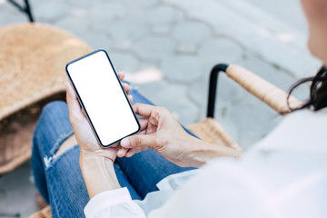 Mockup image blank white screen cell phone.woman hand holding texting using mobile on desk at coffee shop.background empty space for advertise text.people contact marketing business,technology