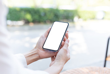 Mockup image blank white screen cell phone.woman hand holding texting using mobile on desk at coffee shop.background empty space for advertise text.people contact marketing business,technology