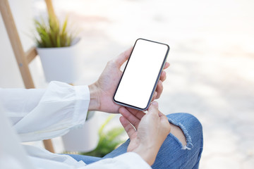 Mockup image blank white screen cell phone.woman hand holding texting using mobile on desk at coffee shop.background empty space for advertise text.people contact marketing business,technology