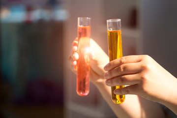 Scientists are carrying test tubes containing bright colored chemicals in the lab