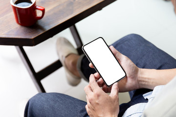 Mockup image blank white screen cell phone.man hand holding texting using mobile on desk at coffee shop.background empty space for advertise text.people contact marketing business,technology