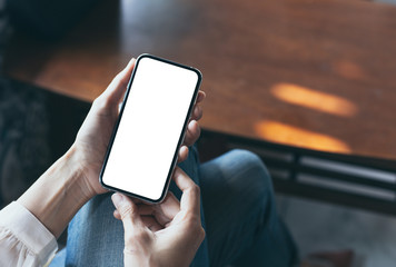 Mockup image blank white screen cell phone.woman hand holding texting using mobile on desk at coffee shop.background empty space for advertise text.people contact marketing business,technology