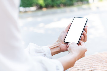 Mockup image blank white screen cell phone.woman hand holding texting using mobile on desk at coffee shop.background empty space for advertise text.people contact marketing business,technology