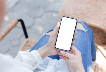 Mockup image blank white screen cell phone.woman hand holding texting using mobile on desk at coffee shop.background empty space for advertise text.people contact marketing business,technology
