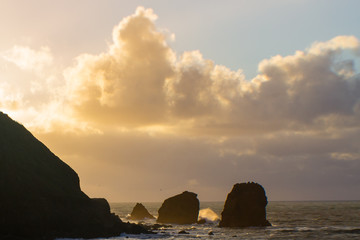 Rocks silhouetted by clouds and sunset.
