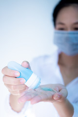 woman wearing hygienic protective mask using wash hand sanitizer alcohol  standing on white background with copy space ,daily protection from corona virus or COVID-19 concept.