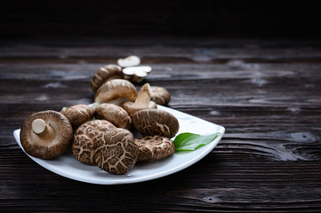 Shiitake mushrooms on the wooden background.