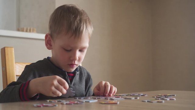 Little boy playing with puzzle, early education concept