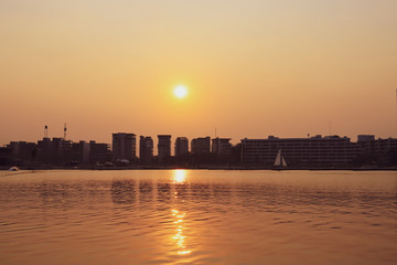 Naklejka premium CItyscape modern apartment building near a lake under sunset twilight with cloud sky background with water reflections for background.