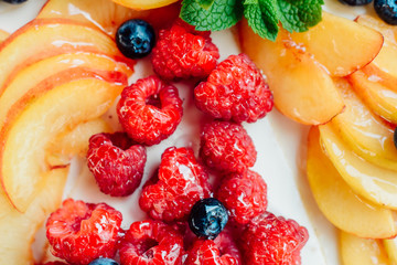 Classic simple new York cheesecake with berries and fruit, close-up view, selective focus