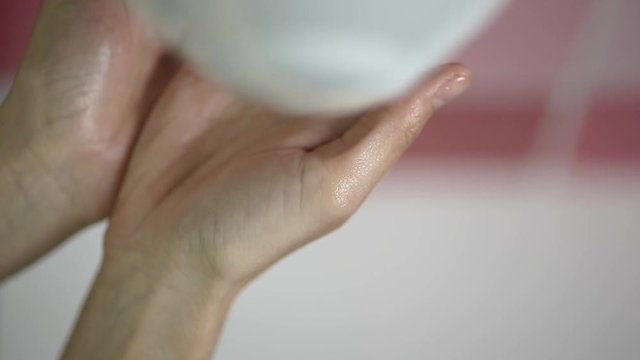 Closeup of woman applying soap in bathroom