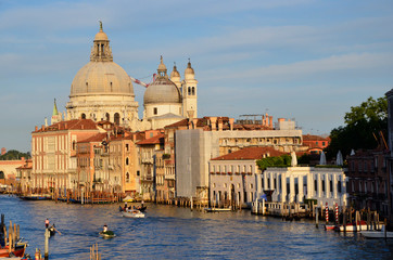 Fototapeta na wymiar Venice's Santa Maria della Salute church dominates this golden hour skyline with he Grand Canal in the foreground.