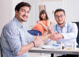 Pregnant woman with her husband visiting the doctor in clinic