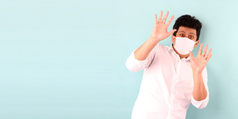 Asian man wearing a mask is Scared sick isolated on blue background in studio With copy space.