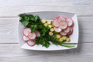 Vegetarian salad with radish, mini corn, cucumber and herbs. Vitamin dish, Fitness diet