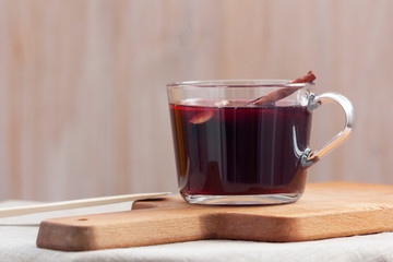 Glass cup of mulled wine on a wooden cutting board