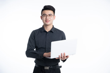 A young Asian man is using his mobile phone and laptop