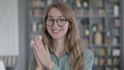 The Portrait of Young Woman Smiling and Clapping in Office