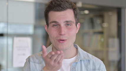 Naklejka premium The Portrait of Attractive Young Male Designer giving Flying Kiss