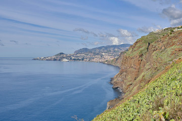 Scenic view of Funchal - capital of Portugal's Autonomous Region of Madeira. Beautiful summer sunny look of small town on hills on paradise tropical island in Atlantic ocean.