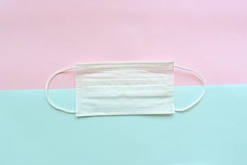 medical hygiene face mask on pink and blue pastel background