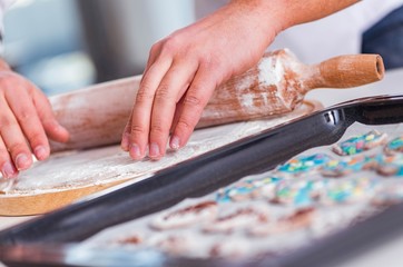 Young man cooking cookies in kitchen