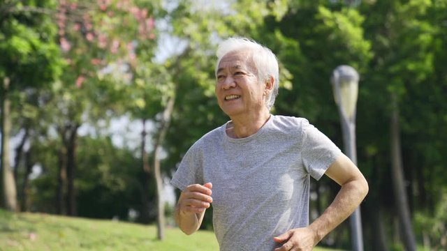 asian old man running jogging outdoors happy and smiling