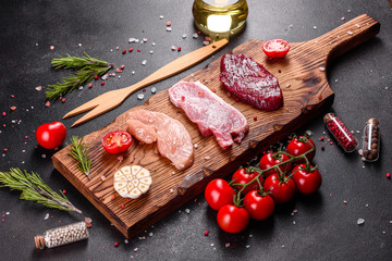 Fresh juicy steak of beef, pork and chicken with vegetables ready to cook