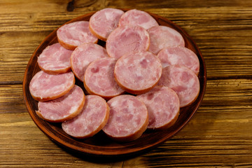 Ham sausage on a plate on wooden table