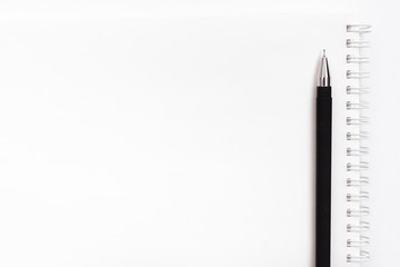 Black pen on white notebook on white background
