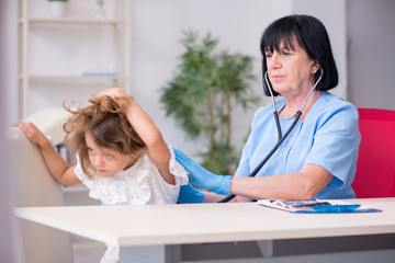 Little girl visiting old female doctor