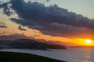 Sunset in a dark cloudy sky at Gerra beach, cantabria