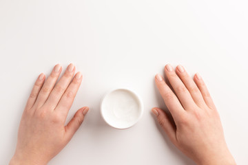 Women hands with container of cream isolated, on white background. Flat lay, top view, copy space. Organic cosmetic concept.