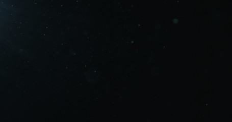 natural dust particles float in air on black background
