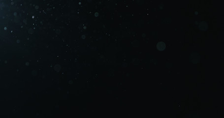 natural dust particles float in air on black background